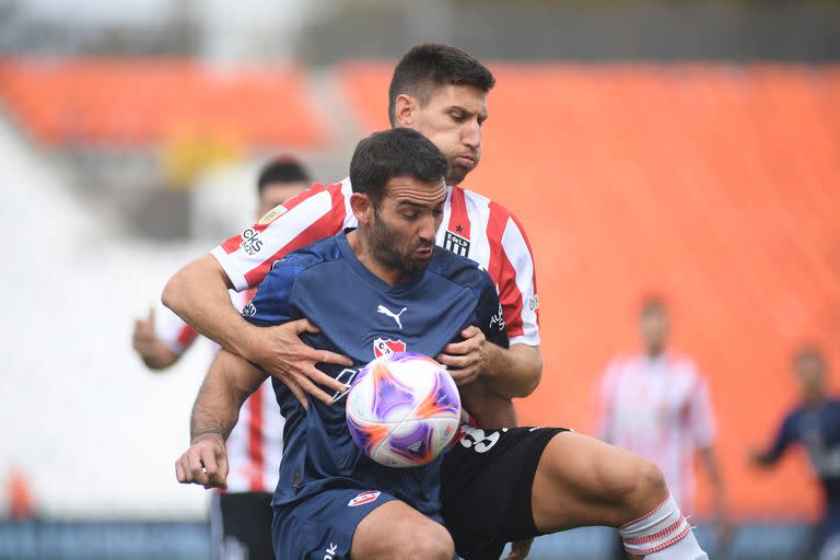 Cuateruccio intenta controla la pelota, encimado por Fernández