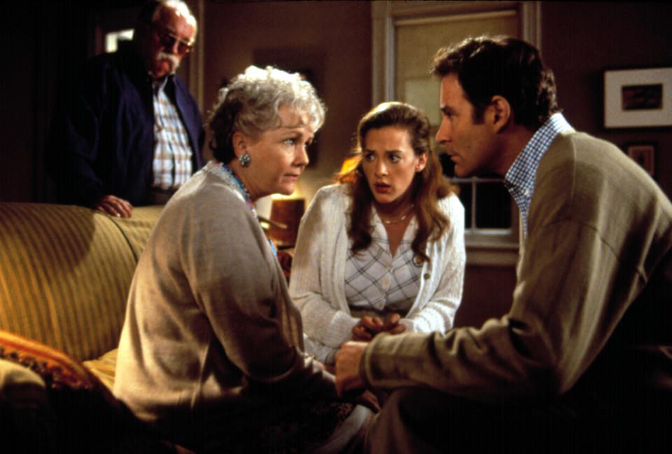 Scene from "The Dead": two older adults, Anjelica Huston and another female, sit on a couch with a young woman, and Donal McCann leans in; an older man in the background