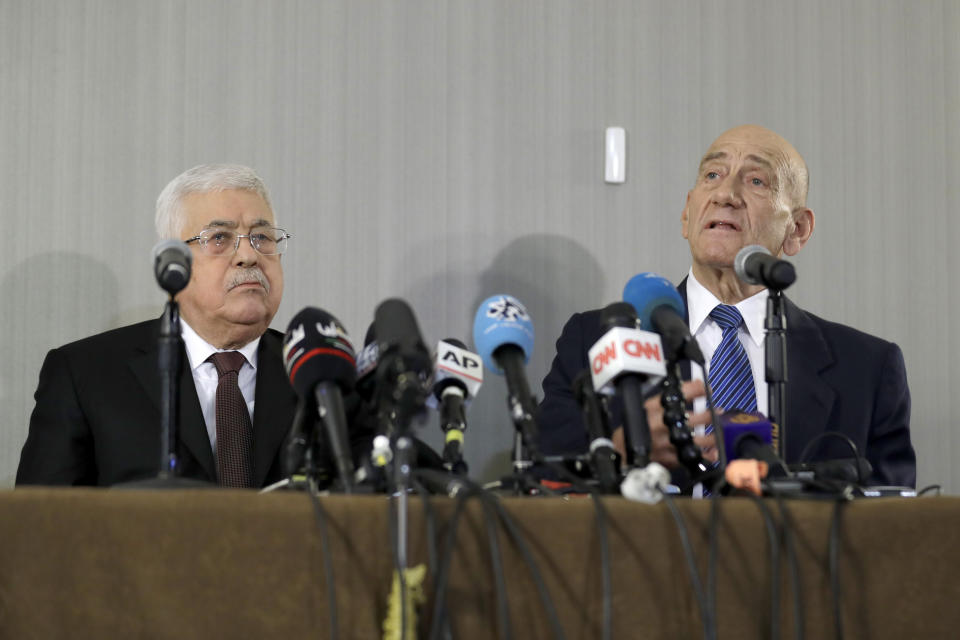 Palestinian President Mahmoud Abbas, left, listens while former Israeli Prime Minister Ehud Olmert speaks during a news conference in New York, Tuesday, Feb. 11, 2020. (AP Photo/Seth Wenig)
