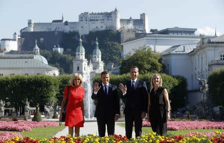 French President Emmanuel Macron and and his wife Brigitte Macron and Austrian Chancellor Christian Kern and his wife Eveline Steinberger-Kern pose for photographers in Salzburg, Austria, August 23, 2017. REUTERS/Heinz-Peter Bader