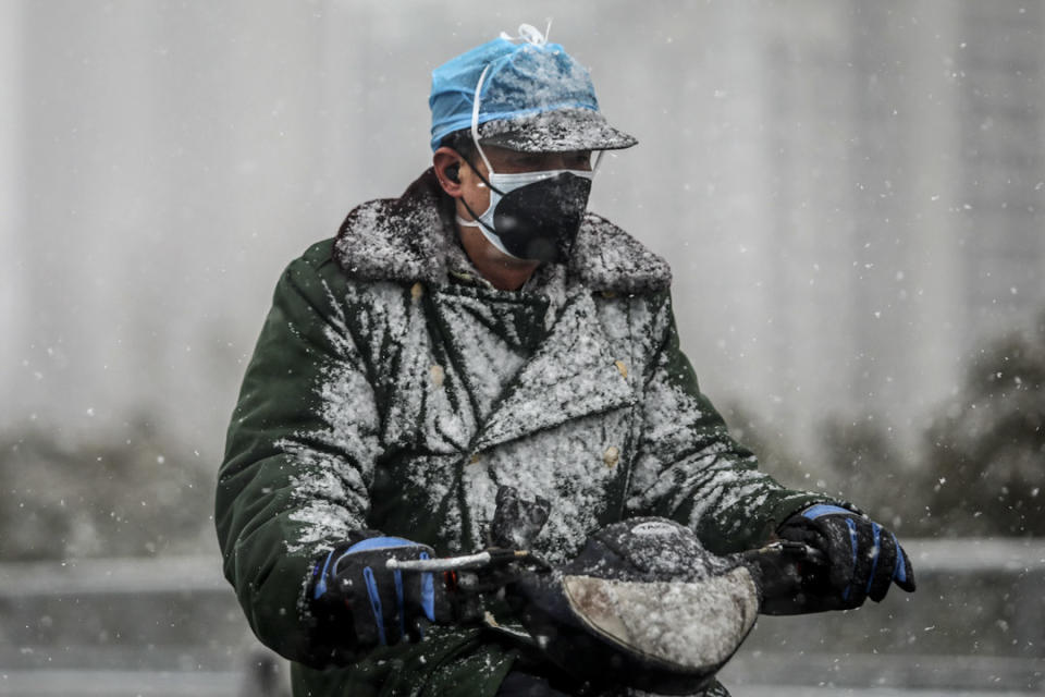 2020年2月15日，武漢一名司機在大雪中騎著電單車。