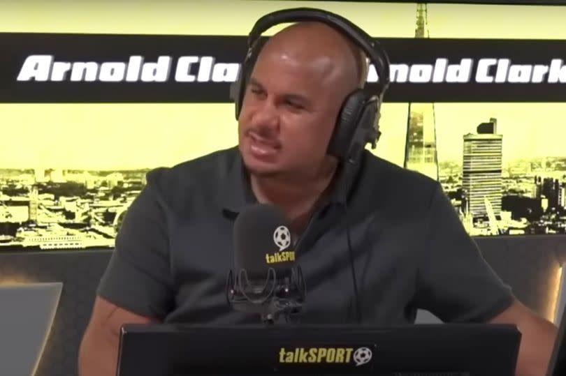 Gabby Agbonlahor talking into a microphone while sitting in the TalkSPORT studio