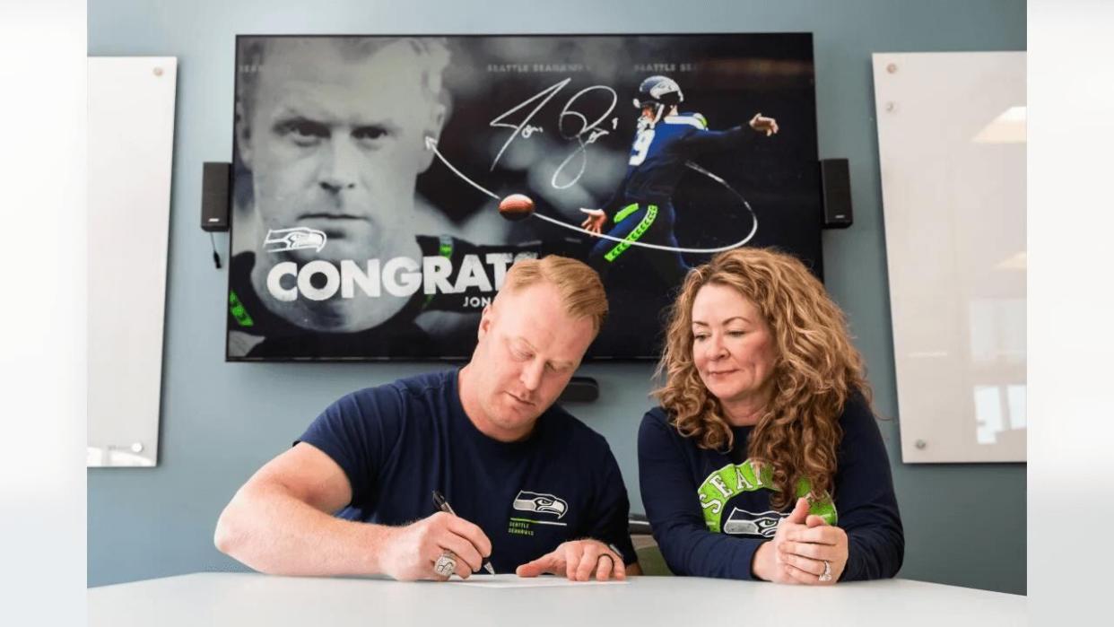 Jon Ryan photographed at the signing alongside his wife, comedian, actor and author Sarah Colonna. (Seattle Seahawks - image credit)
