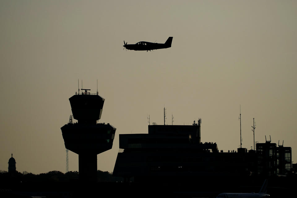 A sports aircraft flies past Tegel Tower, shortly before the last scheduled flight takes off from Berlin's Tegel Airport (TXL) in Berlin, Germany, Sunday, Nov. 8, 2020. With the departure of the Air France aircraft AF 1235 to Paris at 15:00, Tegel Airport will close. (Michael Kappeler/dpa via AP)
