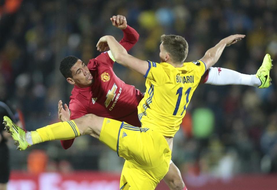 <p>Manchester United’s Chris Smalling, left, and Rostov’s Aleksandr Bukharov fight for the ball </p>