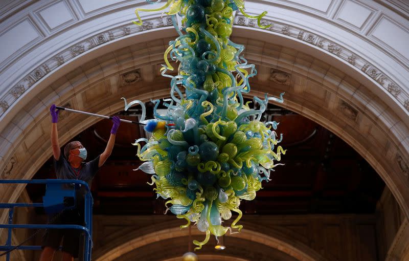 A museum technician cleans the V&A Rotunda Chandelier by Dale Chihuly during preparations to reopen the Victoria & Albert (V&A) Museum, in London