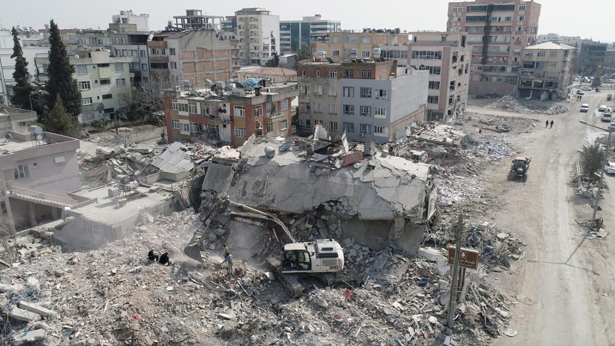 Heavy-duty machines working on debris of collapsed buildings after earthquakes in Turkey.