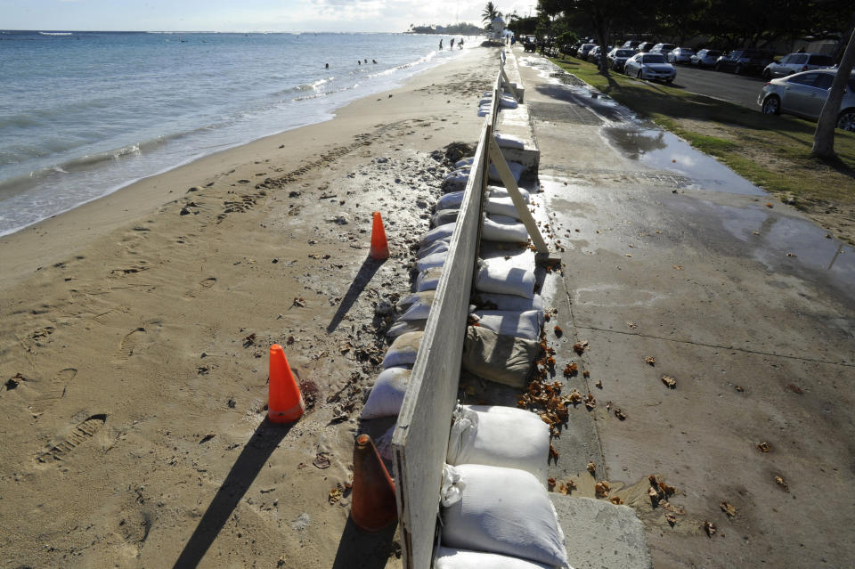 In this June 23, 2017 photo, sand bags line the beach at Ala Moana Beach Park in Honolulu as record high tides hit the islands. Some of Hawaii's most iconic beaches could soon be underwater as rising sea levels caused by global warming overtake its white sand beaches and bustling city streets. That’s alarming for a state where beach tourism is the primary economic driver. (Honolulu Star-Advertiser, Bruce Asato via AP)