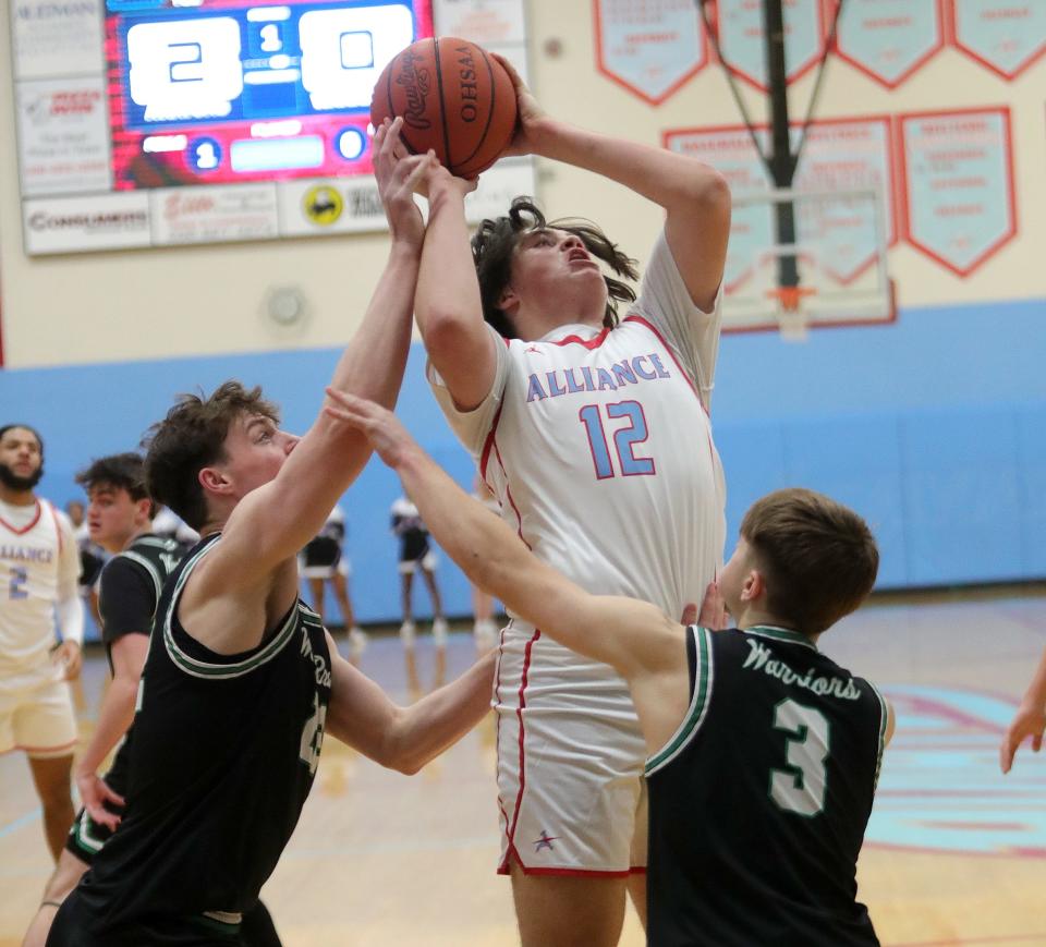 Alliance's Samuel Gress puts up a shot between West Branch defenders Chase Gee, left, and Jeremiah Thomas, Friday, Jan. 26, 2024.