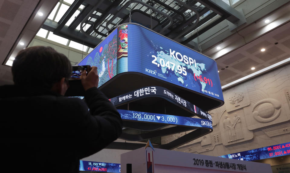 A man takes a photo of screens showing the Korea Composite Stock Price Index (KOSPI) at the Korea Exchange in Seoul, South Korea, Wednesday, Jan. 2, 2019. Asian stock markets have fallen as trading began for 2019 after Chinese factory activity weakened. Benchmarks in Shanghai, Seoul and Hong Kong all declined, while Tokyo was closed. (AP Photo/Lee Jin-man)