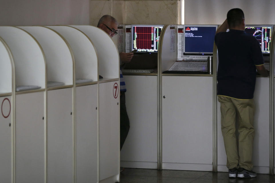 Chinese investors check stock prices at a brokerage house in Beijing, Wednesday, April 24, 2019. Shares were mostly lower in Asia on Wednesday despite the S&P 500’s all-time record high close the day before. (AP Photo/Andy Wong)