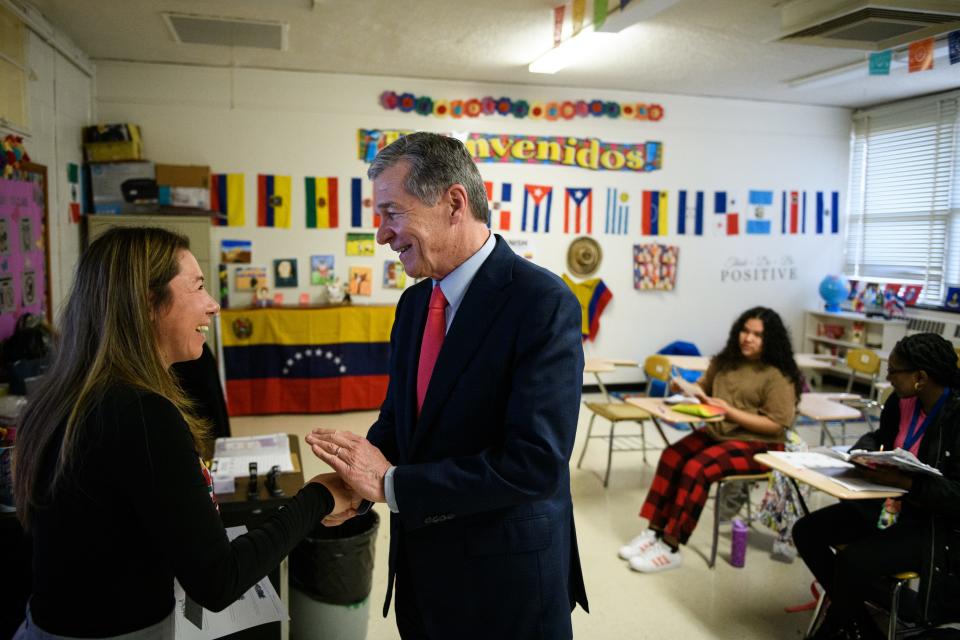 Gov. Roy Cooper shakes hands with Spanish teacher Gina Saavedra while touring E.E. Smith High School on Tuesday, Feb. 27, 2024.