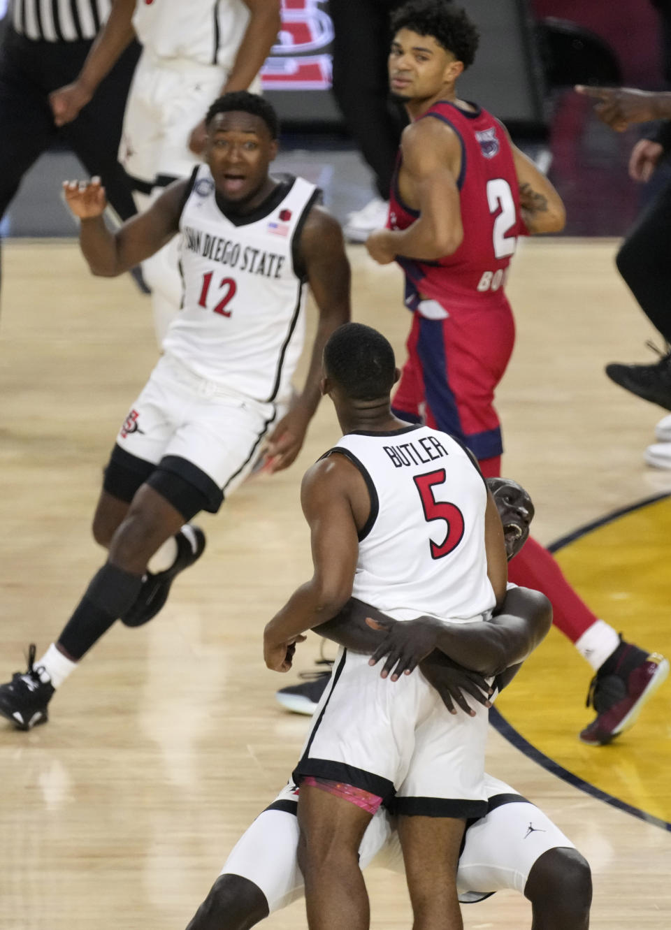 San Diego State forward Aguek Arop picks up teammate guard Lamont Butler (5) after Butler hit the winning shot against Florida Atlantic during the second half of a Final Four college basketball game in the NCAA Tournament on Saturday, April 1, 2023, in Houston. (AP Photo/Godofredo A. Vasquez)