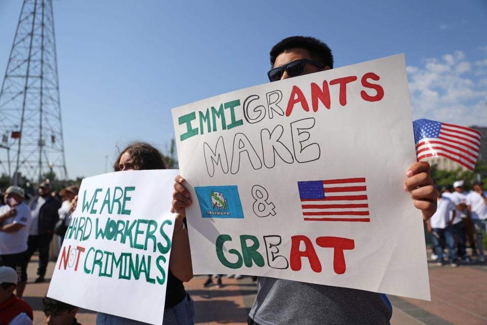 Martin Ramirez, right, and Michelle Solis hold signs during a demonstration in support of the immigrant community before Hispanic Cultural Day Wednesday at the Oklahoma Capitol.