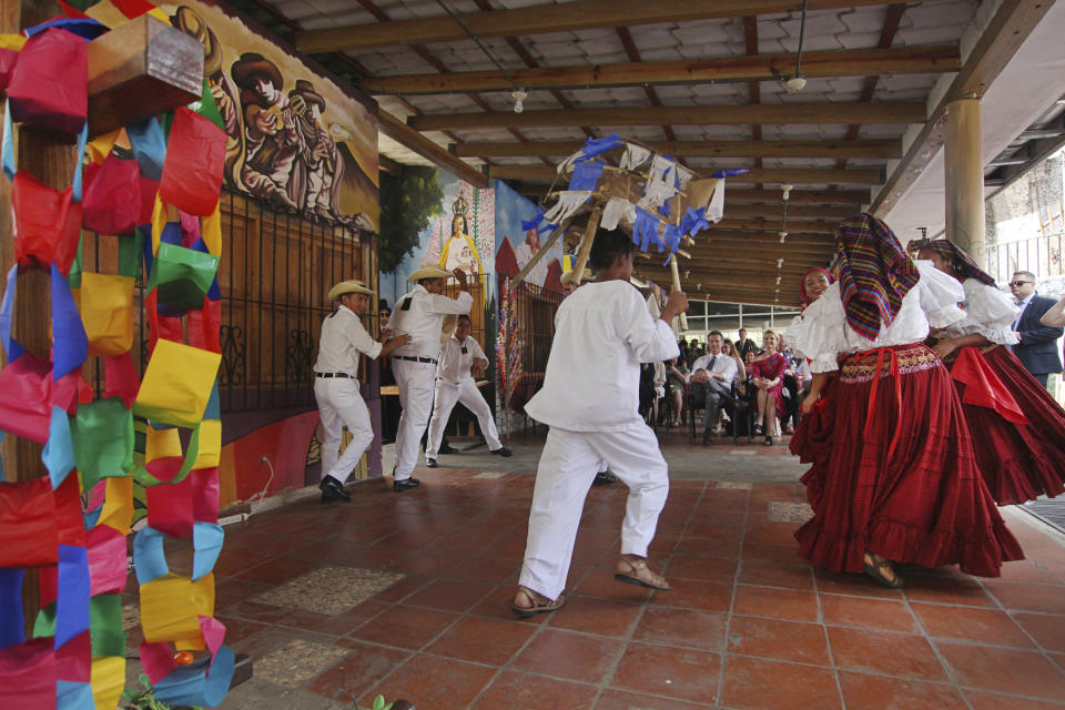 California Gov. Gavin Newsom, center in the background, and his wife, Jennifer Siebel Newsom, watch a traditional dance by young Salvadorans at a cultural center that aims to teach children traditional crafting, song and dance to help them build job skills in Panchimalco, a rural community surrounded by largely gang-controlled areas, in El Salvador, Monday, April 8, 2019. (AP Photo/Salvador Melendez)