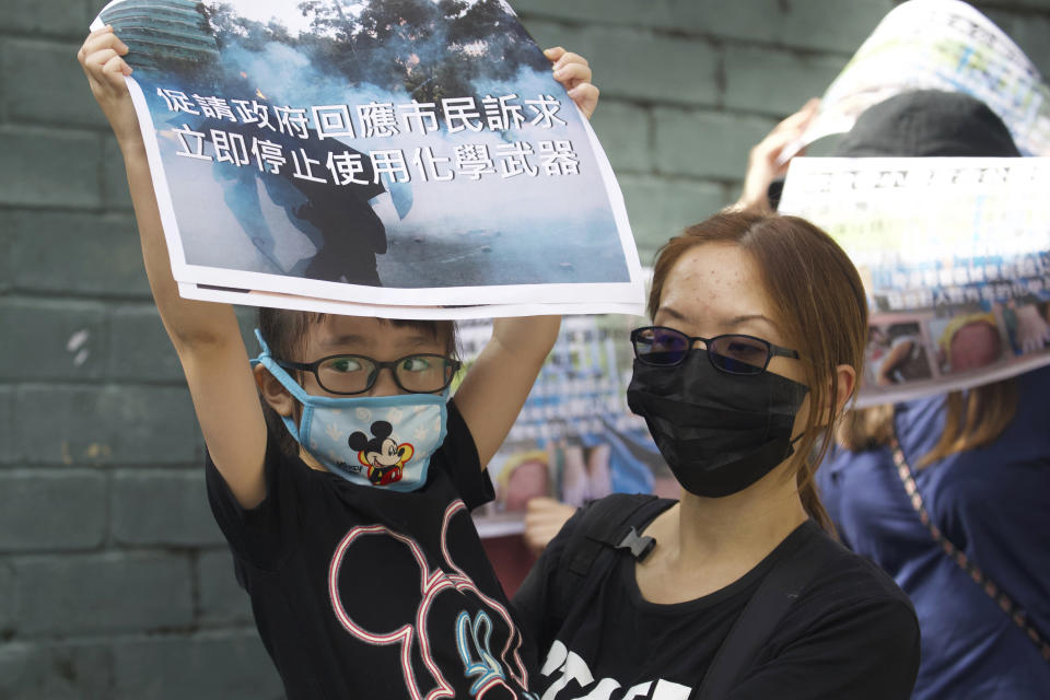 Un niño sostiene un cartel con la frase "Pedimos al gobierno que responda inmediatamente a las peticiones de los ciudadanos y deje de usar armas químicas", durante una protesta contra la exposición de los menores a los gases lacrimógenos empleados por la policía, en Hong Kong, el 23 de noviembre de 2019. (AP Foto/Ng Han Guan)