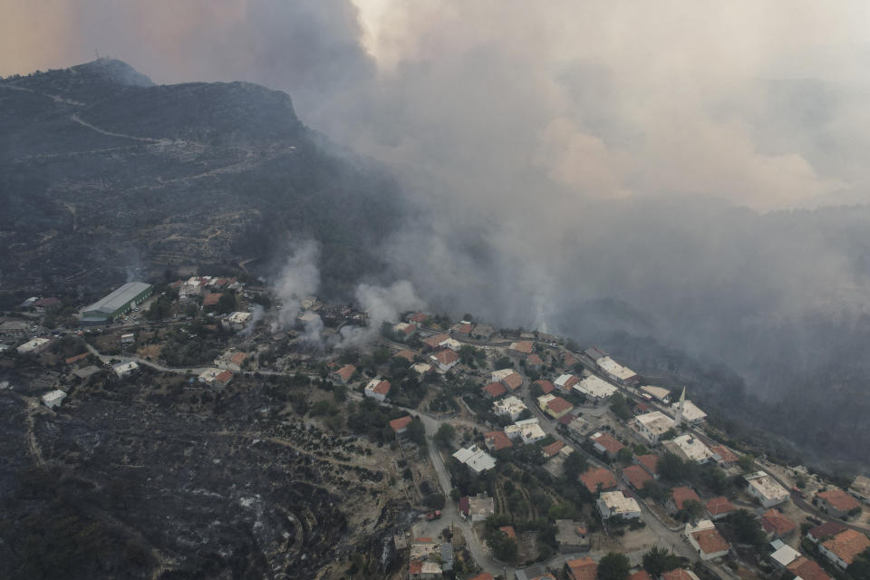 An aerial view of burning Sirtkoy village, near Manavgat, Antalya, Turkey, Sunday, Aug. 1, 2021. More than 100 wildfires have been brought under control in Turkey, according to officials. The forestry minister tweeted that five fires are continuing in the tourist destinations of Antalya and Mugla. (AP Photo)