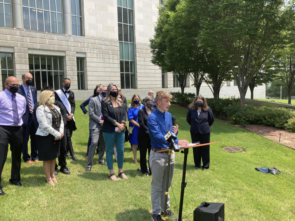 FILE - Dylan Brandt speaks at a news conference outside the federal courthouse in Little Rock, Ark., July 21, 2021. Brandt, a teenager, is among several transgender youth and families who are plaintiffs challenging a state law banning gender confirming care for trans minors. A Little Rock pharmacist's testimony before a legislative committee about gender affirming care for minors resulted in an Arkansas lawmaker asking about her genitalia. The exchange highlights the type of hostile rhetoric that transgender people say they’re facing at statehouses across the country.(AP Photo/Andrew DeMillo, File)