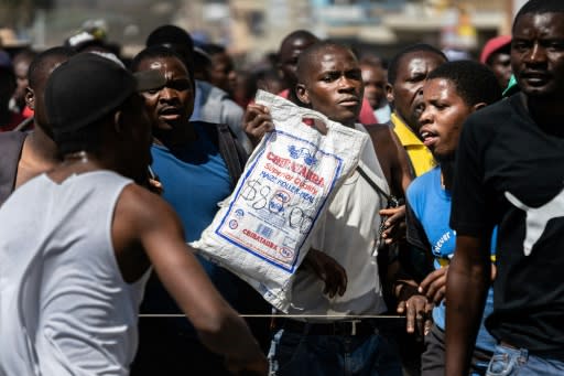 A protester holds a bag of corn meal with a price written on it. Soaring inflation and shortage of basic goods have fuelled anger