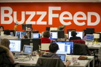 The BuzzFeed logo is displayed on the wall as employees work at the company's headquarters in New York January 9, 2014. REUTERS/Brendan McDermid/Files