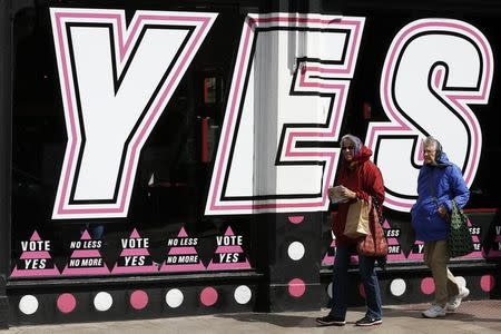 People walk past posters supporting the Yes vote, in the Caple Street area of Dublin in Ireland May 18, 2015. REUTERS/Cathal McNaughton