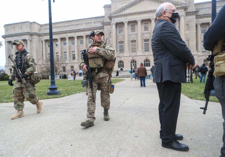 As armed members of the Three Percenters patrol the grounds, Kentucky state Sen. Michael Nemes talks to other protesters on Saturday at a "patriot rally" outside the state Capitol in Frankfort.