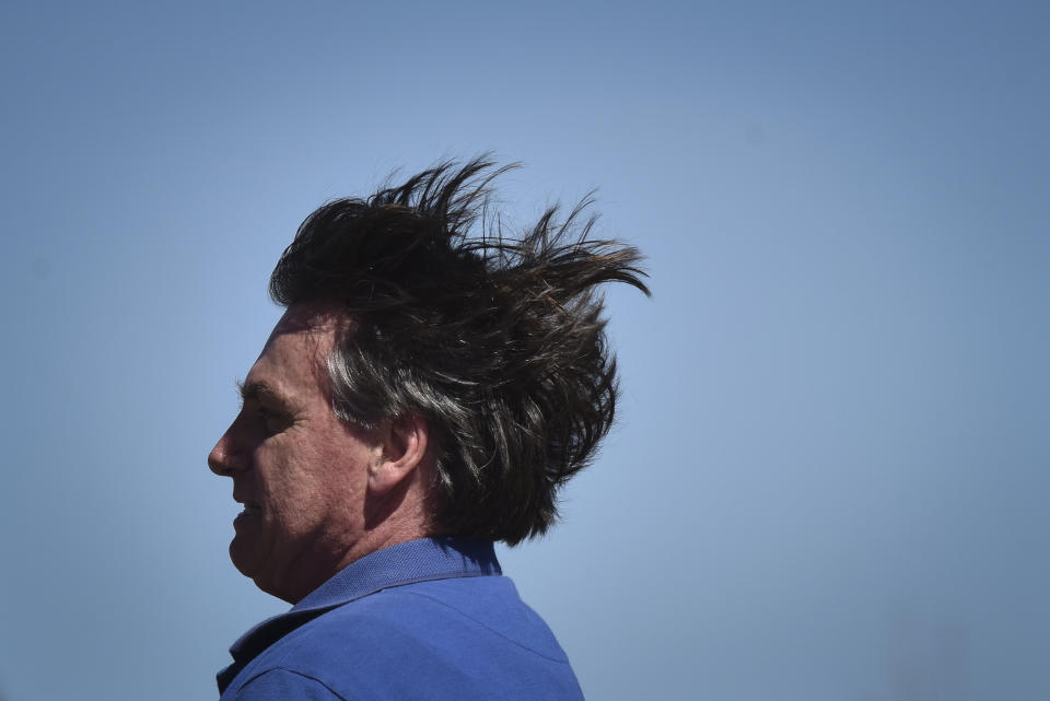 Brazil's President Jair Bolsonaro rides a horse greeting supporters outside the presidential palace in Brasilia, Brazil, Sunday, May 31, 2020. Bolsonaro mounted a horse from police that were guarding supporters of his government gathered outside the Planalto Palace. (AP Photo/Andre Borges)