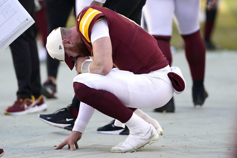 Washington Commanders quarterback Carson Wentz (11) reacts on the sideline after throwing a late interception during the second half of an NFL football game against the Cleveland Browns, Sunday, Jan. 1, 2023, in Landover, Md. (AP Photo/Patrick Semansky)