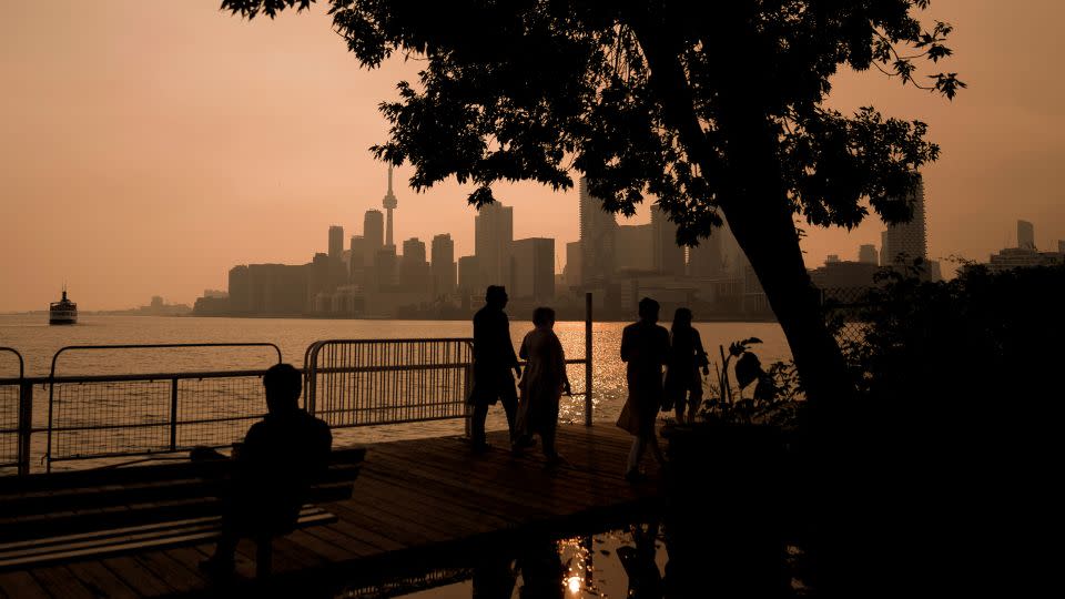 People watch the sunset as the smoke from wildfires drifts into Toronto on Wednesday. - Chris Young/The Canadian Press/AP