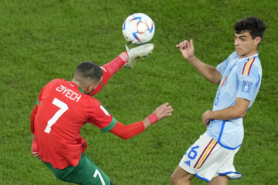 Morocco's Hakim Ziyech, left, controls the ball past Spain's Pedri during the World Cup round of 16 soccer match between Morocco and Spain, at the Education City Stadium in Al Rayyan, Qatar, Tuesday, Dec. 6, 2022. (AP Photo/Ricardo Mazalan)