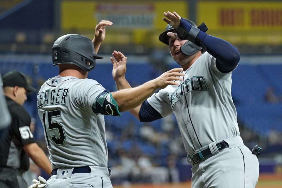 Seattle Mariners' Ty France, right, and Kyle Seager celebrate after scoring on a two-run single by Jake Fraley off Tampa Bay Rays' Michael Wacha during the third inning of a baseball game Monday, Aug. 2, 2021, in St. Petersburg, Fla. (AP Photo/Chris O'Meara)