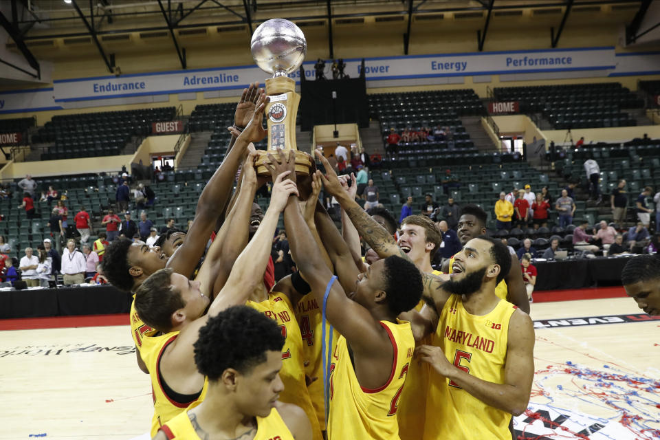 Maryland players celebrate with the Orlando Invitational Trophy after defeating Marquette during an NCAA college basketball game Sunday, Dec. 1, 2019, in Lake Buena Vista, Fla. (AP Photo/Scott Audette)