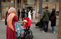 People stand in a queue to enter into a Medical Center, as medical staff check them, during an outbreak of coronavirus disease (COVID-19) in Barcelona