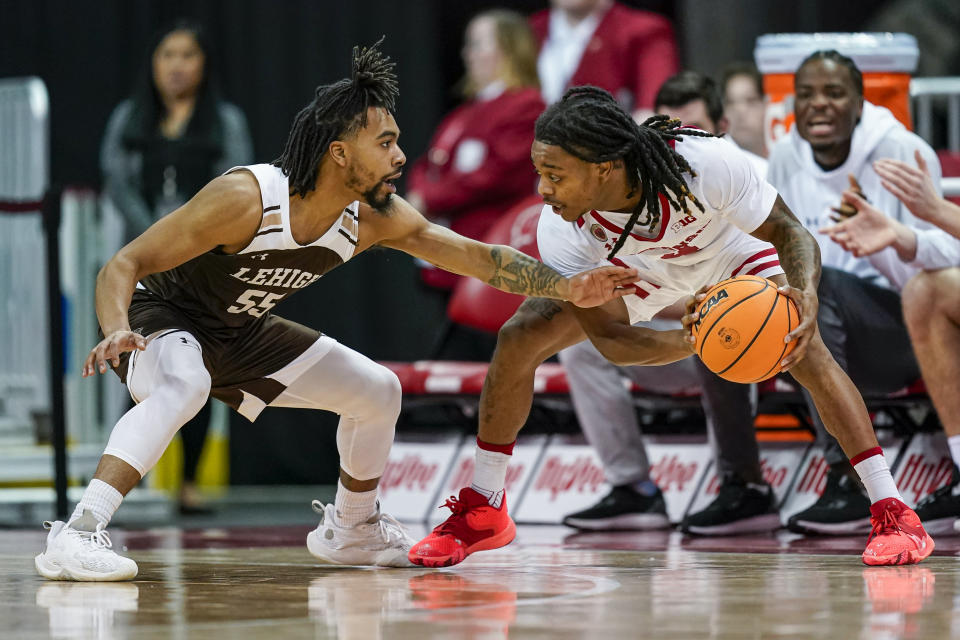 Lehigh's Jalin Sinclair (55) reaches in on Wisconsin's Kamari McGee (4) during the first half of an NCAA college basketball game Thursday, Dec. 15, 2022, in Madison, Wis. (AP Photo/Andy Manis)