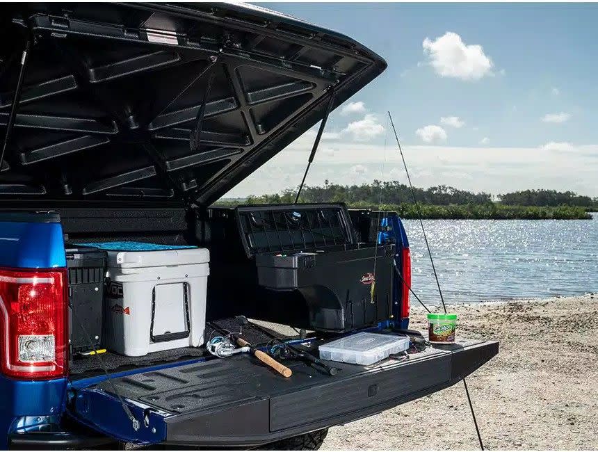 a pickup truck bed filled with gear and topped by a tonneau cover