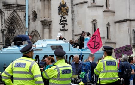 Extinction Rebellion climate activists hold a protest outside the Royal Courts of Justice in London