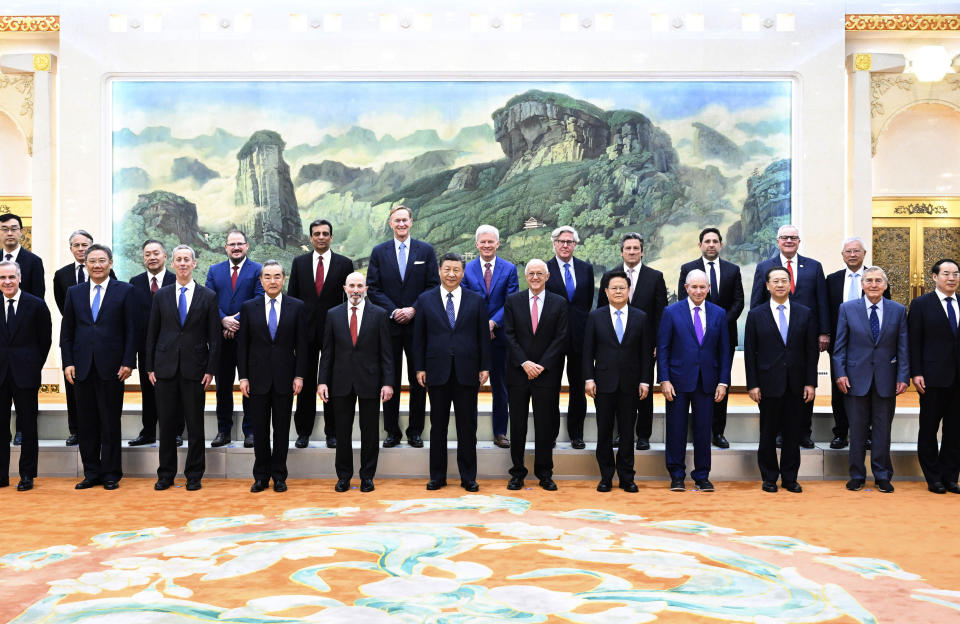 In this photo released by Xinhua News Agency, Chinese President Xi Jinping, center, poses for photos with representatives from American business, strategic and academic communities at the Great Hall of the People in Beijing, March 27, 2024. (Shen Hong/Xinhua via AP)