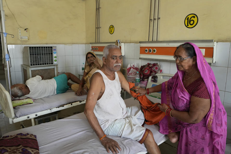 Shiela Mishra wipes the hand of her ailing brother to keep him cool from the heat wave using a wet cloth at the district hospital in Ballia, Uttar Pradesh state, India, Monday, June 19, 2023. Several people have died in two of India's most populous states in recent days amid a searing heat wave, as hospitals find themselves overwhelmed with patients. More than hundred people in the Uttar Pradesh state, and dozens in neighboring Bihar state have died due to heat-related illness. (AP Photo/Rajesh Kumar Singh)