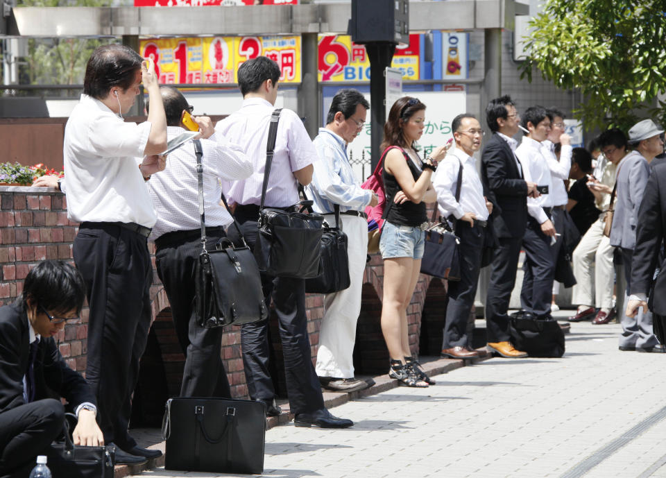 In this June 29, 2012 photo, Japanese office workers wait for their colleagues in front of a railway station in Tokyo. Government data showed Tuesday, July 31, Japan's unemployment rate for June improved slightly to 4.3 percent, declining for the second straight month, but the nation continues to struggle after last year's disaster. The Ministry of Internal Affairs and Communications reported that the jobless rate last month fell 0.1 percentage point from 4.4 percent in May. (AP Photo/Koji Sasahara)