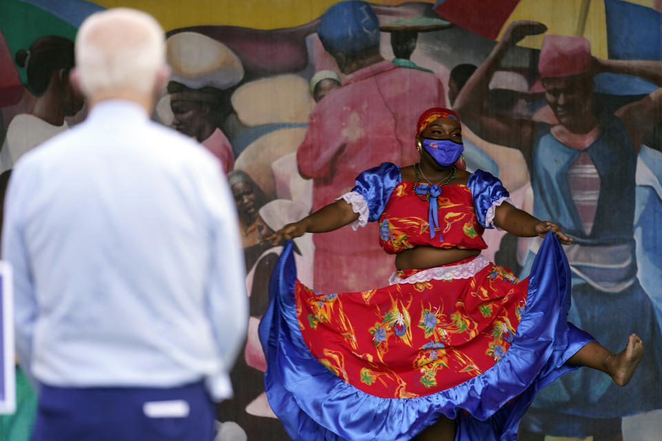 Dancers perform as Democratic presidential candidate former Vice President Joe Biden watches during a visit Little Haiti Cultural Complex, Monday, Oct. 5, 2020, in Miami. (AP Photo/Andrew Harnik)