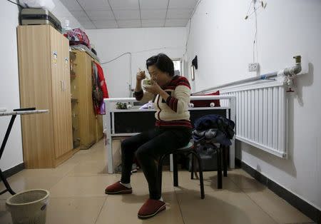 Migrant worker Lai Yongmei, 47, eats her breakfast as she prepares for her daily commute into Beijing, China, November 16, 2015. REUTERS/Kim Kyung-Hoon