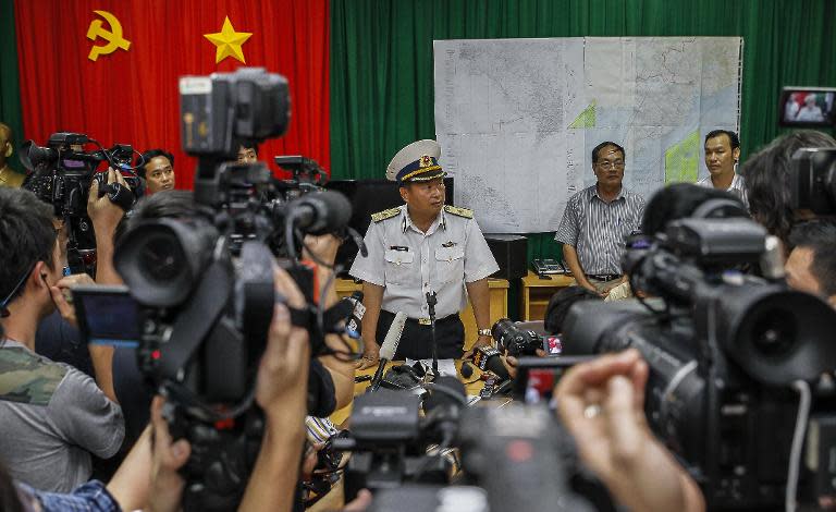 Vietnamese Navy Deputy Commander Rear Admiral Le Minh Thanh (C) speaks to reporters during a press conference on search activities for the missing Malaysia Airlines flight 370 in Phu Quoc island on March 12, 2014