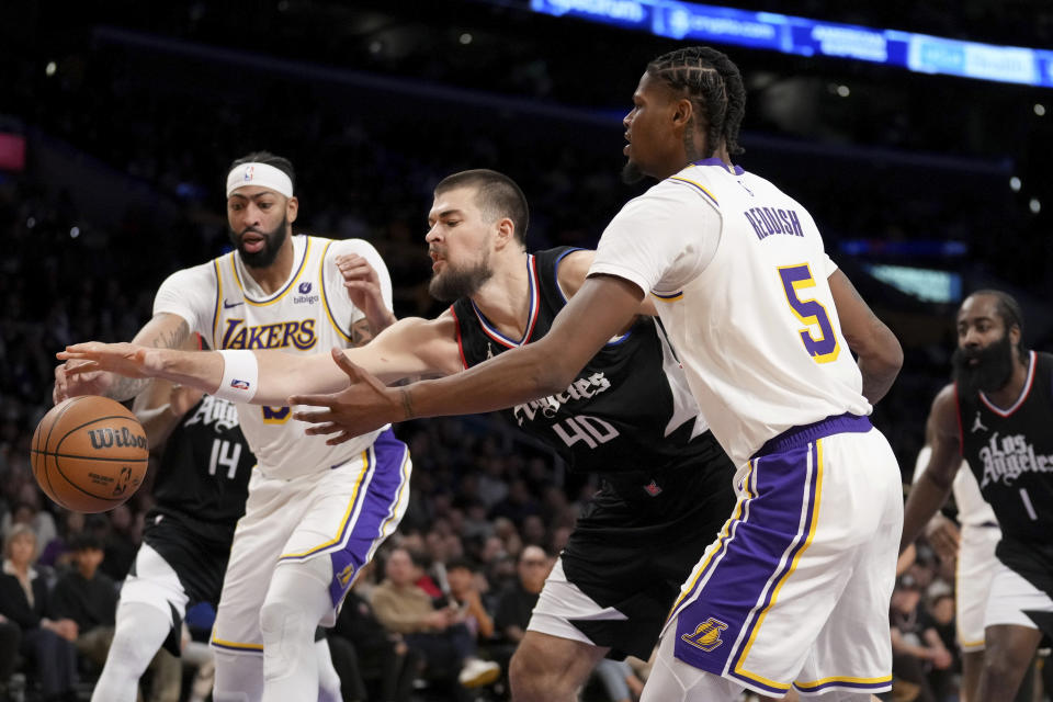 Los Angeles Lakers forward Anthony Davis, front left, and forward Cam Reddish (5) fight for a rebound against Los Angeles Clippers center Ivica Zubac (40) during the first half of an NBA basketball game in Los Angeles, Sunday, Jan. 7, 2024. (AP Photo/Eric Thayer)