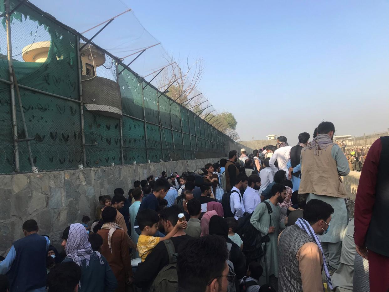 Afghans gather near a gate of Kabul airport in Kabul, Afghanistan, Aug. 22, 2021. Seven Afghan civilians were killed amid chaos near the Kabul airport as people swarmed the area in hopes of boarding an evacuation flight following the Taliban takeover of Afghanistan, Britain's Ministry of Defense said Sunday. (Photo by Rahmatullah Alizadah/Xinhua via Getty)