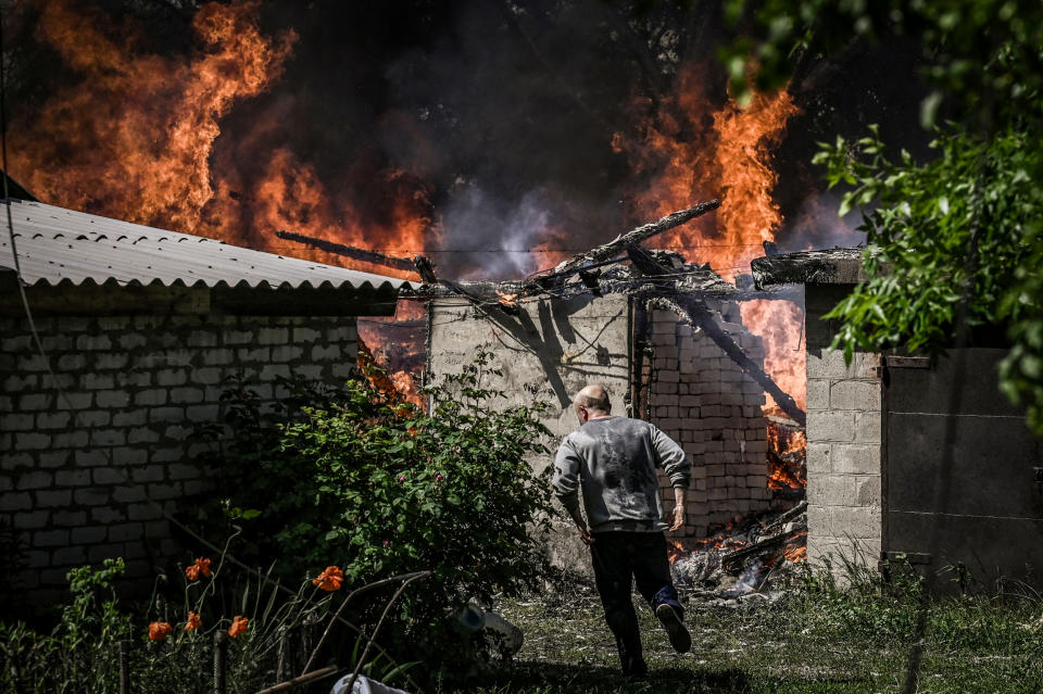 A man walks away from a burning house garage after shelling in the city of Lysytsansk in the eastern Ukrainian region of Donbas on May 30, 2022. (Aris Messinis / AFP - Getty Images)