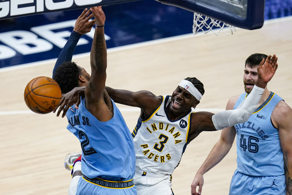 Indiana Pacers guard Aaron Holiday (3) is fouled as he shoots over Memphis Grizzlies forward Xavier Tillman (2) during the second half of an NBA basketball game in Indianapolis, Tuesday, Feb. 2, 2021. (AP Photo/Michael Conroy)