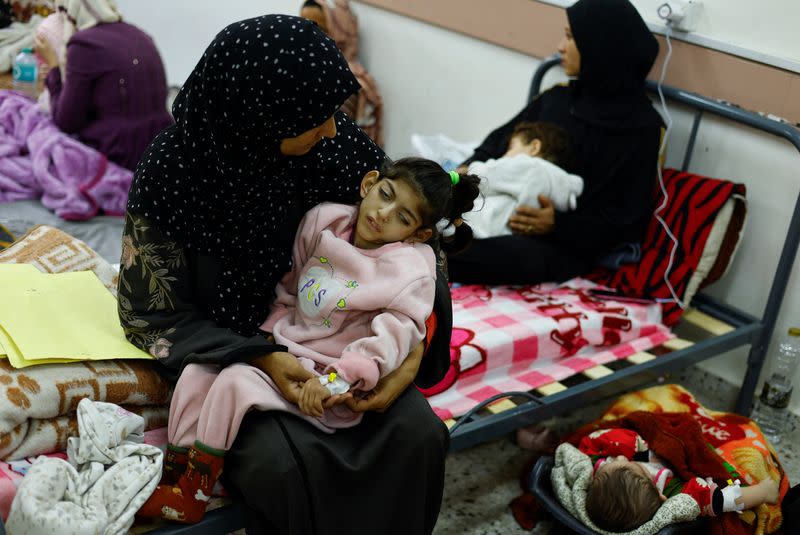 La palestina Umm Mesbah Heji sostiene a su desnutrida hija Israa, tetrapléjica y epiléptica, en el centro de salud de al-Awda, en Ráfah, en el sur de la Franja de Gaza
