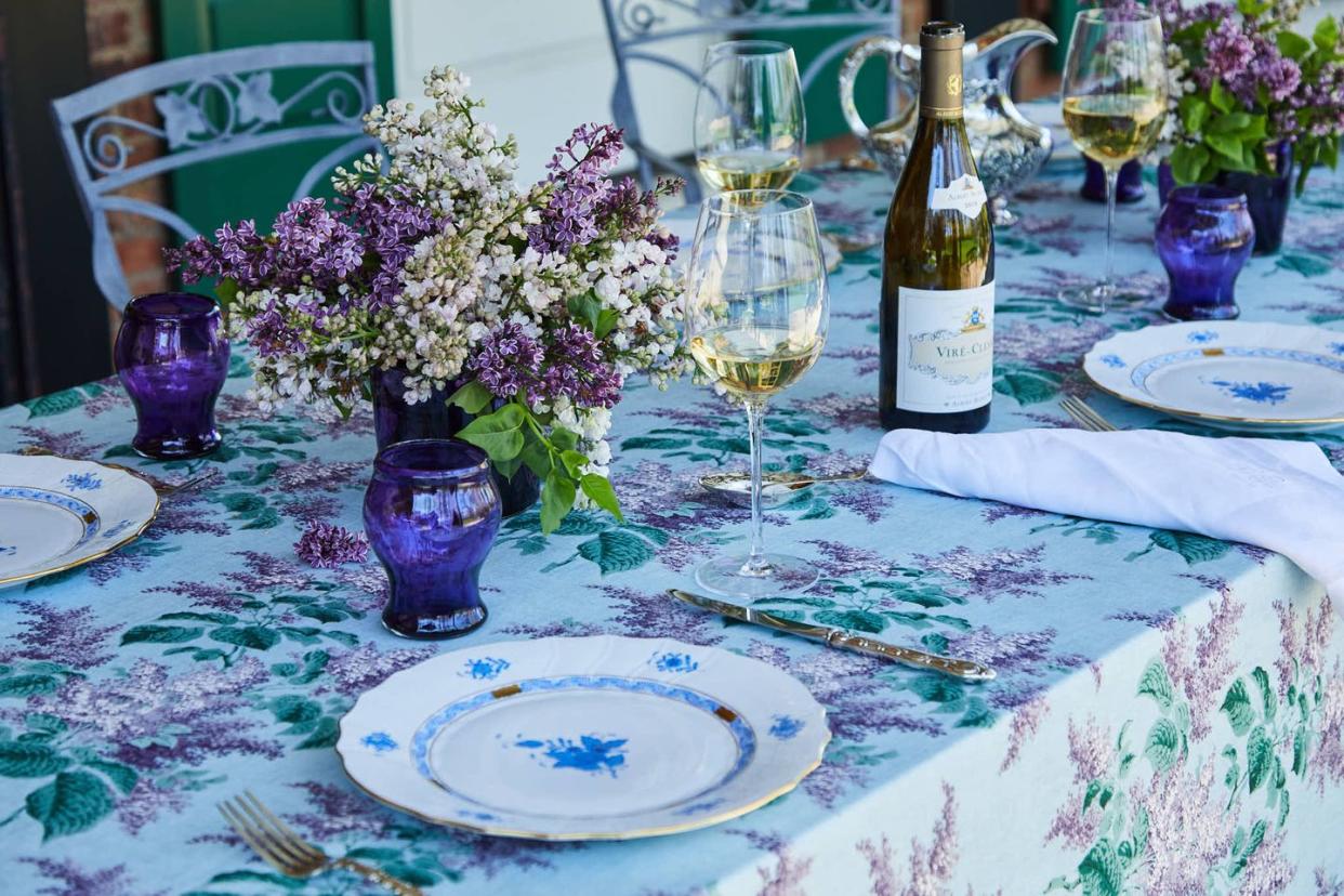 a table with wine glasses and flowers