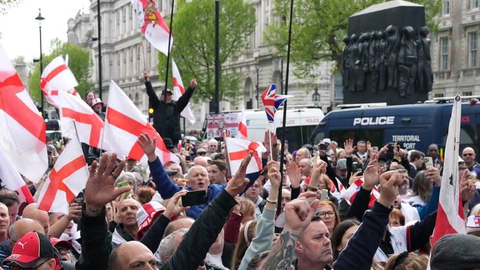 People wave flags during a St George's Day rally on Whitehall