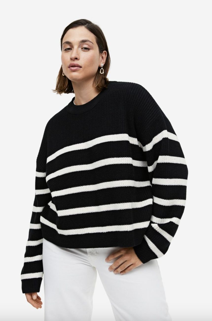 Plus size brunette model in white jeans and black striped rib knit sweater (photo via H&M)